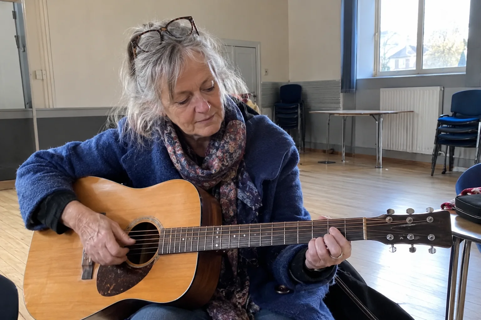 Une femme essaie une guitare dans une salle municipale