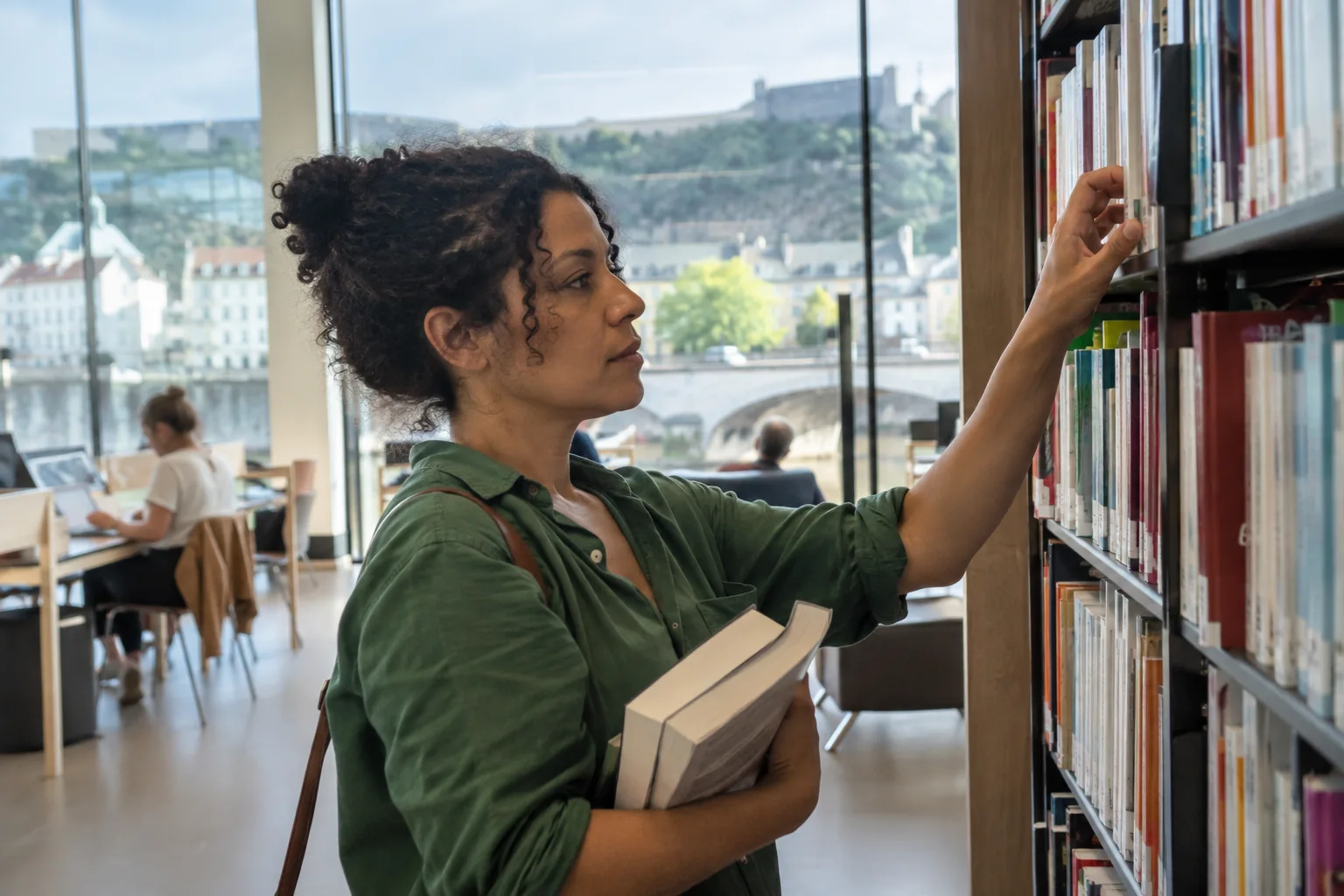Une femme choisit un livre dans une médiathèque
