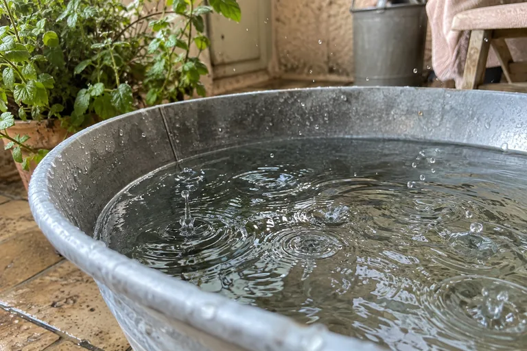 Gouttes tombant dans une bassine métallique remplie d’eau.